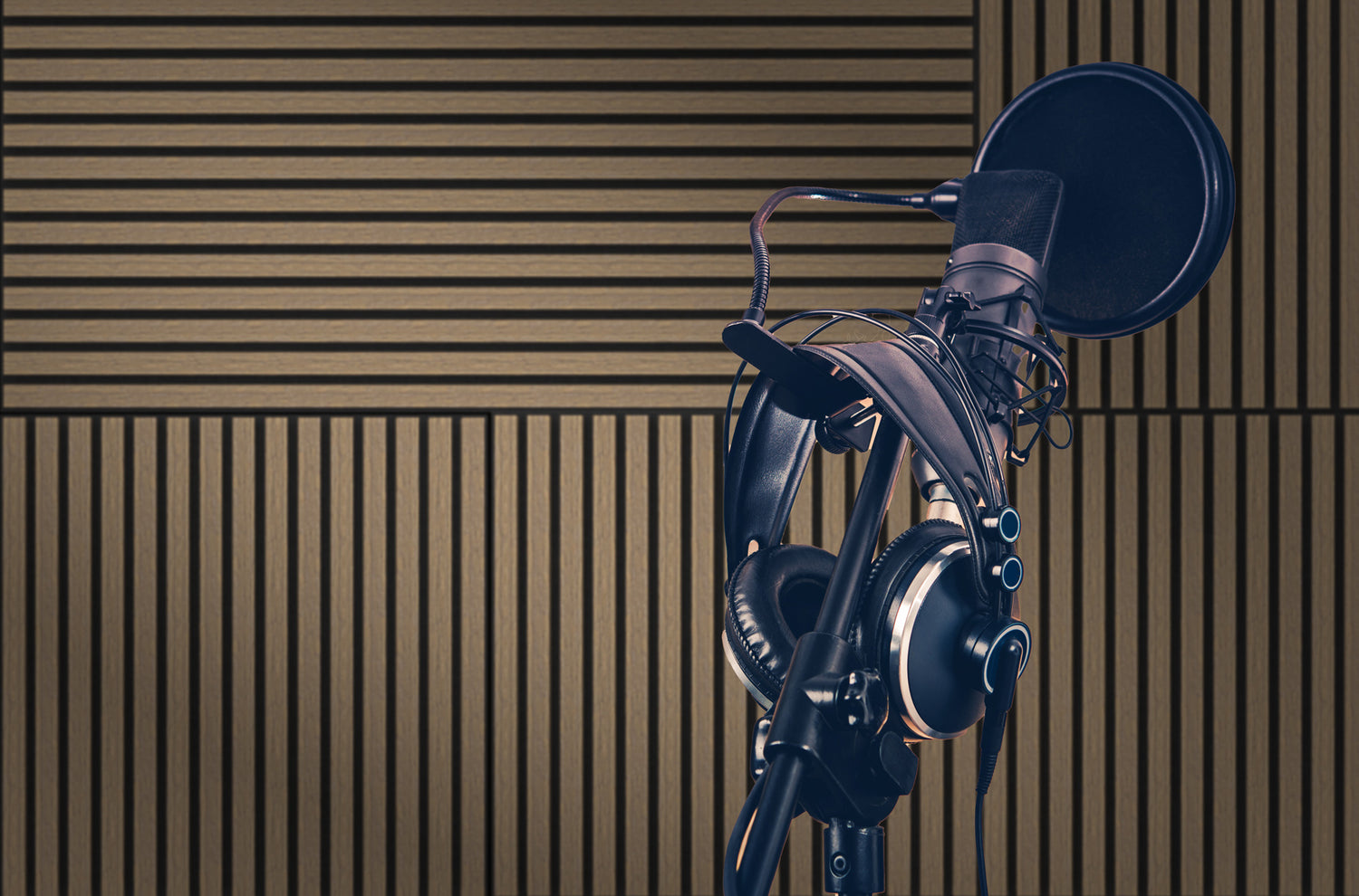 Studio setup with microphone and headphones in front of DECKO acoustic panels, showcasing stylish acoustic wall panels in a modern wood finish